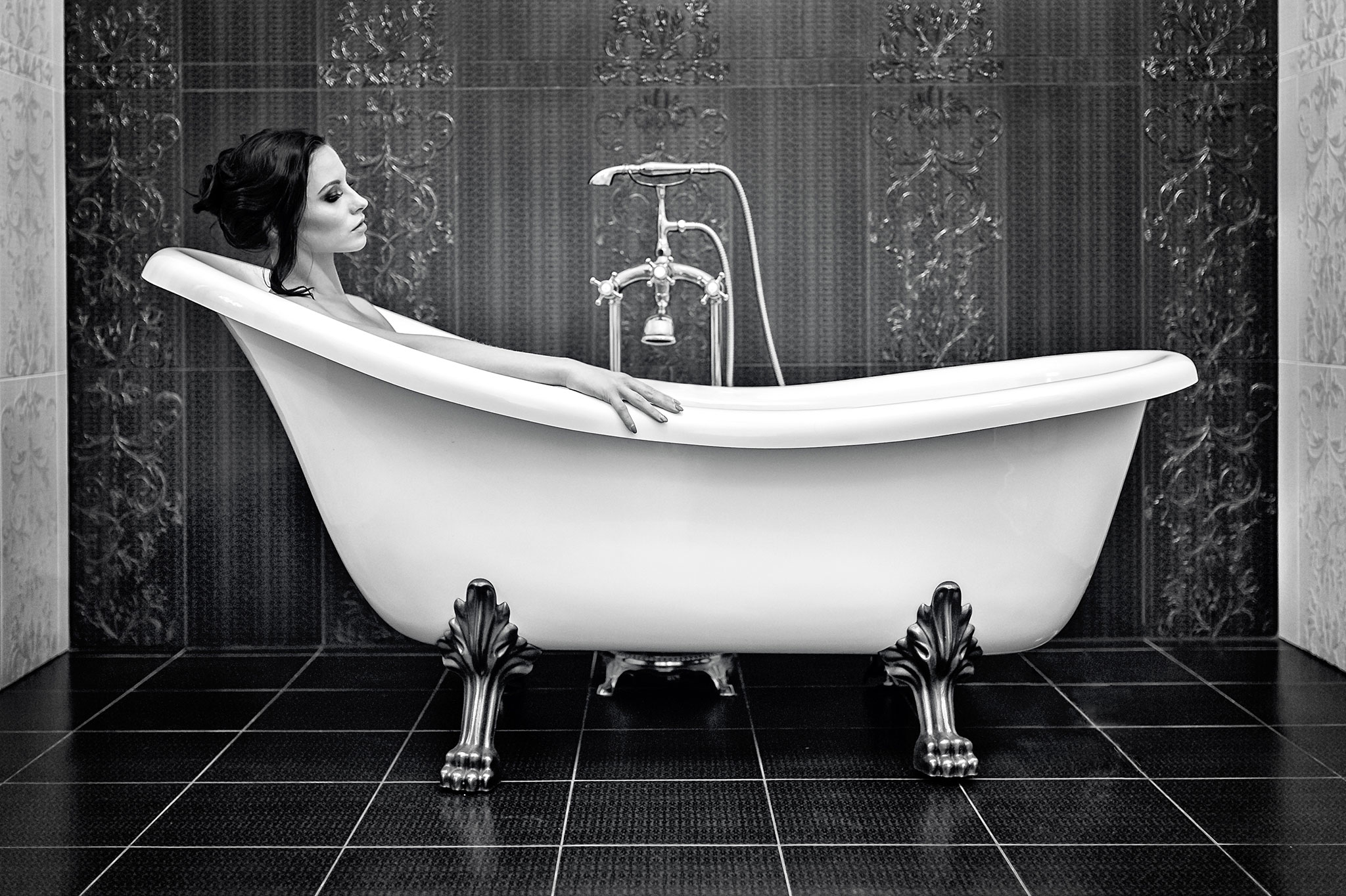 Ettertenksom svarthåret kvinne ligger i et vakkert stilig badekar